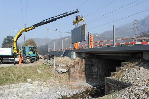 Trabajadores durante la instalación de barreras acústicas en el ferrocarril — Foto de Stock