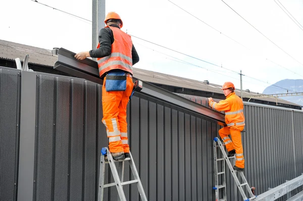 Travailleurs lors de l'installation de barrières antibruit sur le chemin de fer — Photo