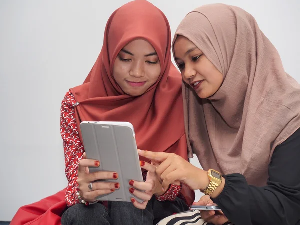 Två muslimska flickor använder en tablet PC — Stockfoto