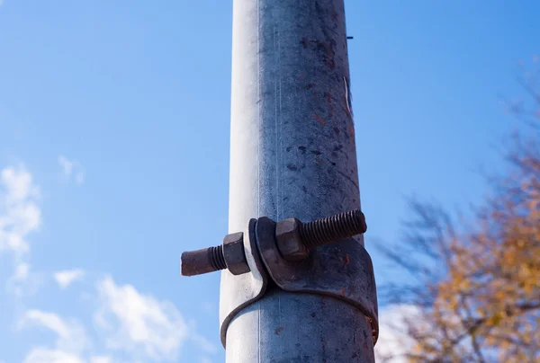 Dirty metal pole with rusted fastener. — Stock Photo, Image