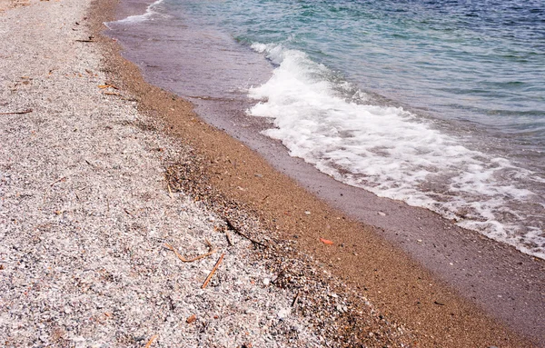 Beach kaba kum ve taşların dalga ile. — Stok fotoğraf