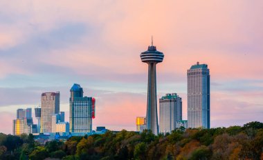 NIAGARA FALLS, CANADA - 27 Ekim 2017: Oteller, kumarhaneler ve Skylon Kulesi gün batımında gökyüzüne hakim.