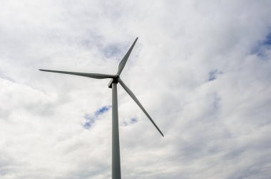 Bulutlu gökyüzüne karşı tek bir rüzgar türbini.