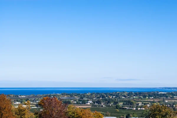 Semi-rural area by lake against big empty sky — Stock Photo, Image