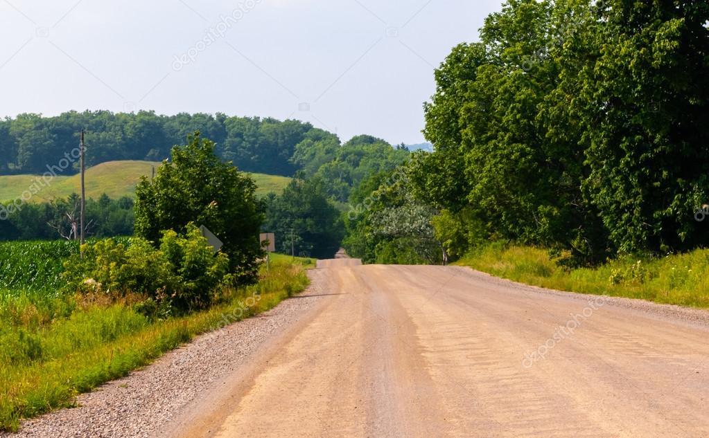 Dirt road against hills and trees