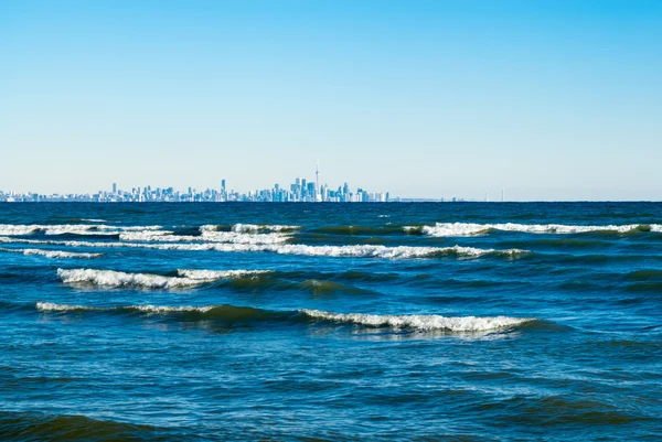Olas rompiendo en el lago con el horizonte de Toronto en la distancia . — Foto de Stock