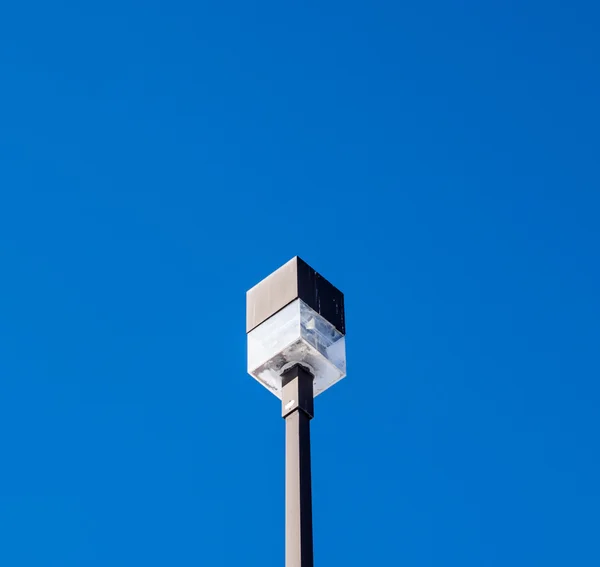 Square outdoor light on post on blue sky. — Stock Photo, Image