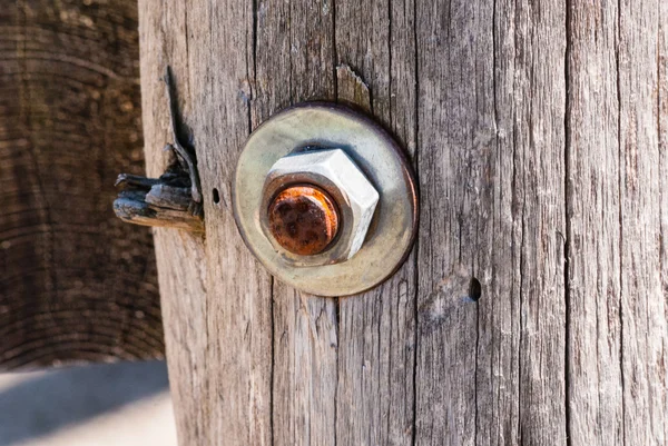 Verrostete Metallschraube mit Mutter in Holzpfosten. — Stockfoto