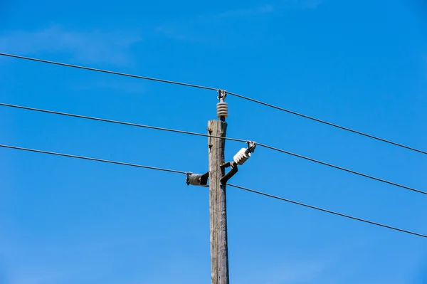 Old simple rural wood electrical pole on blue sky — Stock Photo, Image