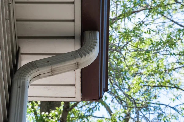 Tubo downspout cinza que conduz para baixo de eavestrough — Fotografia de Stock