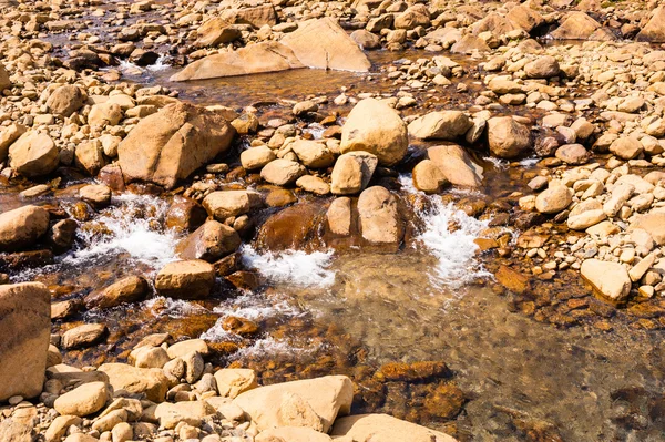 NET sığ su akan ve çıplak kayaların üzerinde sıçramasına — Stok fotoğraf