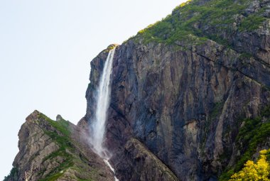 Kayaların üzerinde dik kayalıklarla üzerinden akan yüksek şelale