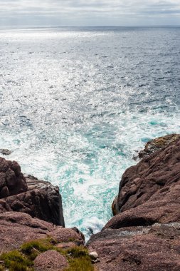 Su ve dik kayalık okyanus giriş bulut altında sıçramasına dalgalar