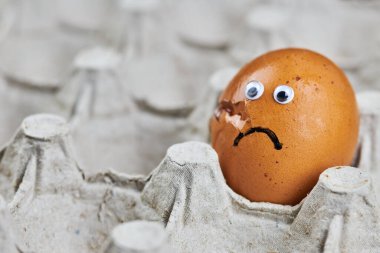 Kağıt yumurta tepsisinde kırık yumurta. Paskalya yumurtası gözlerle çatlamış, komik bir duygu. Teslimat hasar konsepti, kopyalama alanı.