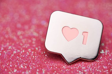 Kalp sembolü gibi. İşaret düğmesi, kalp ve tek haneli sembol gibi. Sosyal medya ağı pazarlaması. Pembe parıltı arka planda kıvılcımlar.