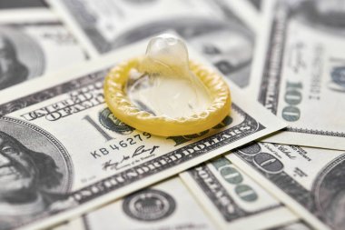 Prezervatif ve banknot. Fuhuş konsepti. Doğum kontrol hapı olan bir Amerikan doları. Gecelik seks için para öde. Fahişelik ve fahişelik..