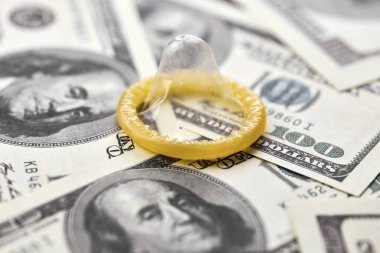 Prezervatif ve banknot. Fuhuş konsepti. Doğum kontrol hapı olan bir Amerikan doları. Gecelik seks için para öde. Fahişelik ve fahişelik..