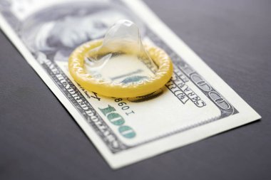 Prezervatif ve banknot. Fuhuş konsepti. Doğum kontrol hapı olan bir Amerikan doları. Gecelik seks için para öde. Fahişelik ve fahişelik..