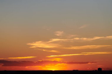 Gün batımı gökyüzü. Şehrin ufuk çizgisinde güzel manzaralı bir akşam. Renkli gün batımı. Alacakaranlıkta hava açık.