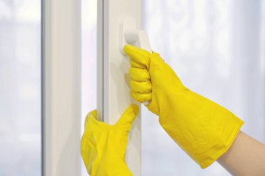 Koruyucu sarı lastik eldiven plastik pencereyi açar ve kapatır, PVC. Temizlik, bakım ve onarım.