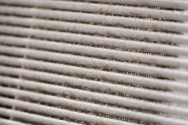 Extremely dirty air ventilation grill of HVAC with dusty clogged filter, macro. close up. Cleaning and disinfecting is needed to prevent dust allergies and risk of other lung illnesses. Shallow DOF.