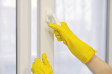 Koruyucu sarı lastik eldiven plastik pencereyi açar ve kapatır, PVC. Temizlik, bakım ve onarım.
