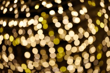 Bokeh 'in parıldayan yıldızları. Kutlama için sarı parıltılar. Siyah arkaplan