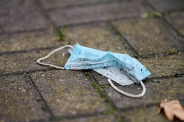 Yerde tıbbi maske kullanılmış. Aşıdan sonra atılan anti koronavirüs maskesine gerek yok. CORONAVIRUS salgınının sonu. COVID muhalif konsepti. Çevre kirliliği.