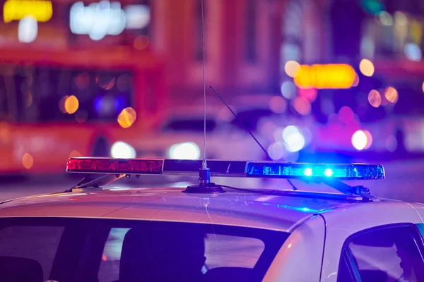 Gece şehir caddesindeki polis arabasının ışıkları. Kırmızı ve mavi ışıklar. Trafik kazası. Akşam devriyesi.