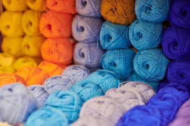 Örgü ve dikiş için raflardaki yün yumakları ya da yün yumakları, kapatın. Kumaş mağazasındaki tuhafiyeciler için aksesuarlar. Renkli resim, arkaplan.