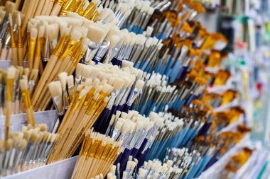 Kırtasiyede rafta duran yeni sanatsal boya fırçaları, kapat. Kahverengi ya da beyaz tüylü ahşap fırçalar. Resim aletleri alışverişi konsepti.