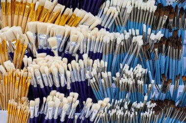 Kırtasiyede rafta duran yeni sanatsal boya fırçaları, kapat. Kahverengi ya da beyaz tüylü ahşap fırçalar. Resim aletleri alışverişi konsepti.