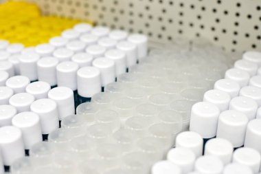 Ek malzemeler veya gıda ürünleri için yuvarlak kapaklı plastik silindir kavanozlar. İlaç endüstrisi için raflarda duran beyaz opak kaplar. Paket tasarımı için hazır.