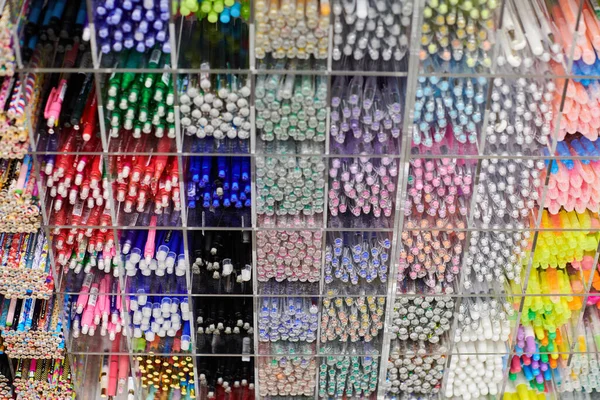 Colored pens, pencils and markers on shelves in shop. Office supplies and stationery. Colorful pens arranged on shelf. Multicolored pens in art store. Art, workshop, craft, creativity concept.