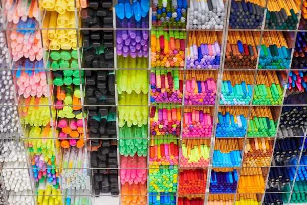 Colored pens, pencils and markers on shelves in shop. Office supplies and stationery. Colorful pens arranged on shelf. Multicolored pens in art store. Art, workshop, craft, creativity concept.