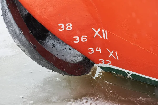 Old ship draft on hull, scale numbering. Distance between waterline and bottom keel. Ship in water.