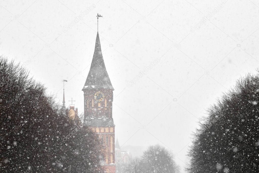 Cathedral in Kaliningrad named after Kant against background of cloudy winter landscape. Konigsberg Cathedral in winter, Christmas snowfall.