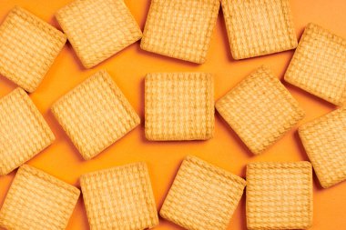 Kare bisküviler, turuncu arka plan. Lezzetli çerez. Kare kurabiyeler.