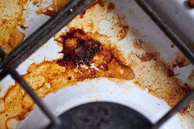Yemek artıklarıyla birlikte kirli yağ sobası. Yağlı lekeleri, eski yağ lekeleri, kızartma noktaları ve yağ lekeleri olan kirli bir mutfak mutfağı..