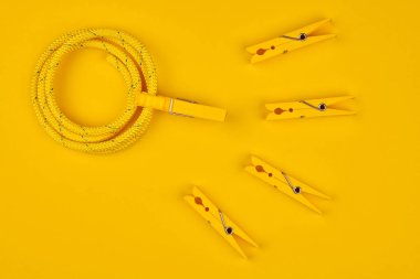 Sarı mandallar ve ip. Sperm yarışması. Döllenme, hamile konsepti. Spermatozoonlar yumurtaya doğru yüzüyor. Sarı arkaplan.