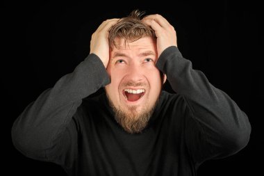 Yorgun sakallı adam portresi, baş ağrısı, siyah arkaplan. Aşırı çalışma, baş ağrısı konsepti. Siyah polo yakalı genç adam. Öfkeli adamı işaret etmekten yorgun ve bitkin düştüm..