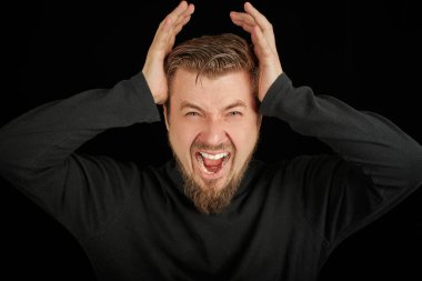 Yorgun sakallı adam portresi, baş ağrısı, siyah arkaplan. Aşırı çalışma, baş ağrısı konsepti. Siyah polo yakalı genç adam. Öfkeli adamı işaret etmekten yorgun ve bitkin düştüm..