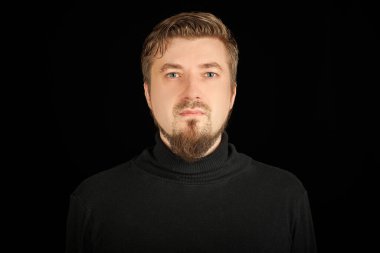 Sevimli sakallı adam, siyah arkaplan. Siyah polo yakalı genç adam. Kendinden emin, başarılı bir adam..