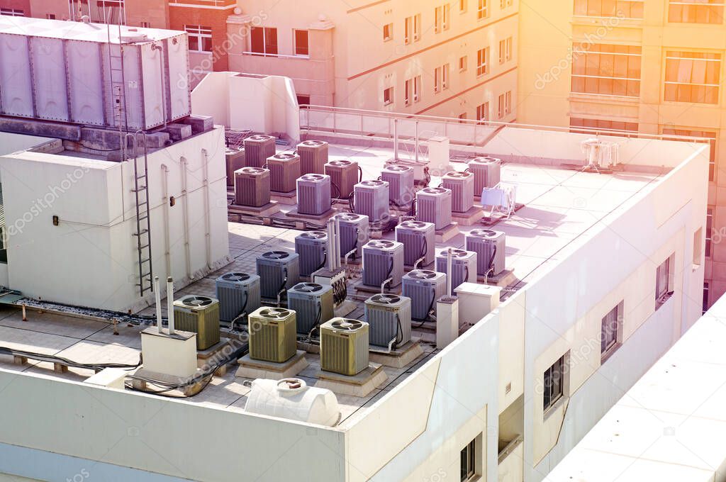 many air conditioners on the roof of the building above view