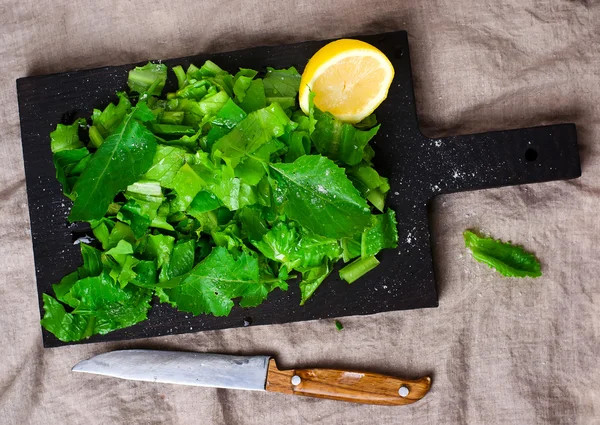 Grön sallad skära på en planka — Stockfoto