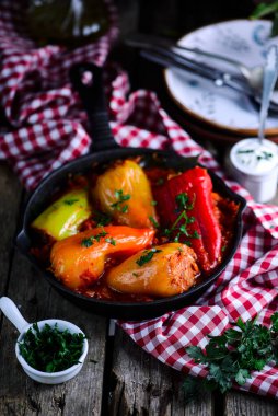 Biberler domates sosunda et ve pirinçle doldurulmuş. Tarz rustik. Seçici odak noktası.