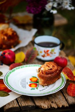 Elmalı çörekler, sonbahar bahçesindeki ahşap bir masada karamel. Koyu kırsal fotoğraf. Seçici odaklanma.