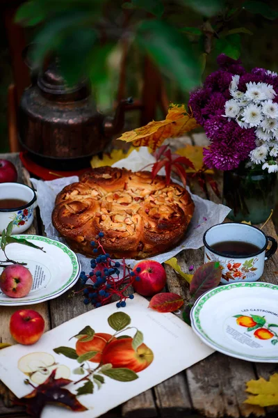 Elmalı çörekler, sonbahar bahçesindeki ahşap bir masada karamel. Koyu kırsal fotoğraf. Seçici odaklanma.
