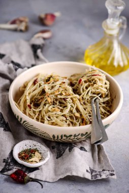 Betondan bir arka planda seramik kasede spagetti alio olio. Seçici odak