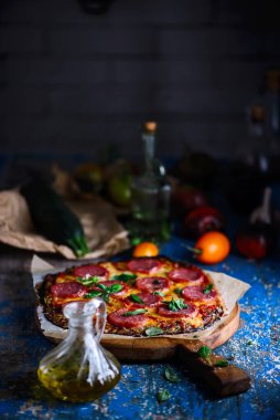 Salamlı ve peynirli kabaklı pizza kabuğu. Kırsal stil. Seçici odaklanma